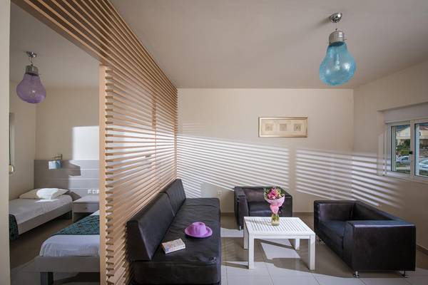 Inneneinrichtung eines Schlafzimmers im Corissia Princess Hotel mit zwei Betten, Sofas, Tisch und Blumen.