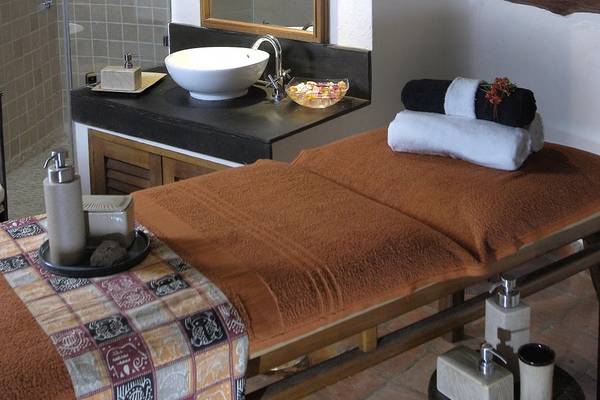 Massageliege im Pinewood Beach Resort & Spa mit einem Waschbecken, Handtüchern und Pflegeprodukten.