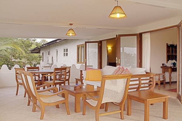 Innenbereich der Terrasse im Pinewood Beach Resort & Spa mit Möbeln und Dekor.