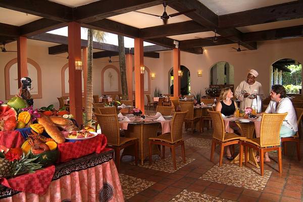 Restaurant im Pinewood Beach Resort & Spa mit gedeckten Tischen und Gästen.