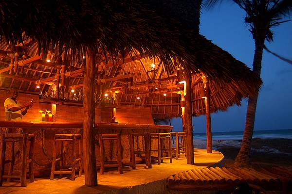Strandbar bei Nacht im Pinewood Beach Resort & Spa mit Palmen und Meeresblick