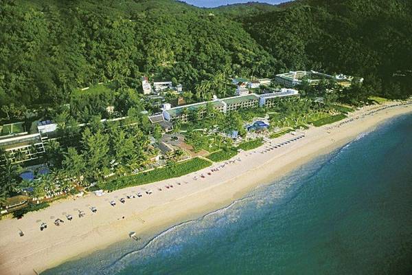 Luftaufnahme des Katathani Phuket Beach Resorts an einem Strand mit vielen Bäumen und Gebäuden.