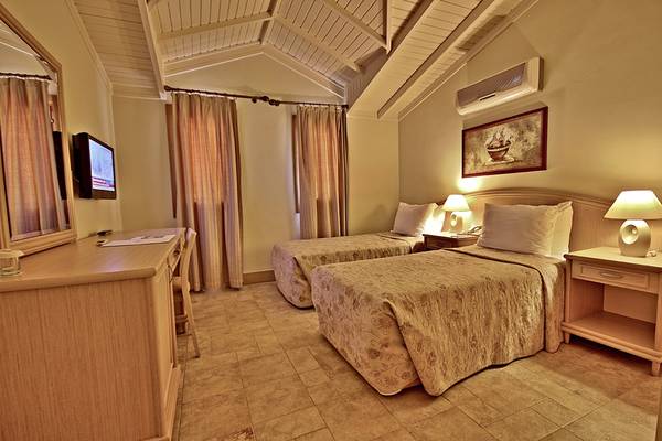 Doppelzimmer im Dalyan Resort Hotel mit zwei Betten, Fernseher, Schreibtisch und Nachttischen.