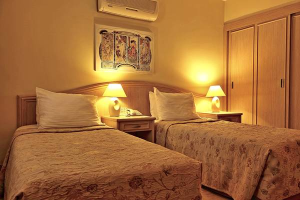 Doppelzimmer im Dalyan Resort Hotel mit zwei Betten, Nachttischen und Lampen.