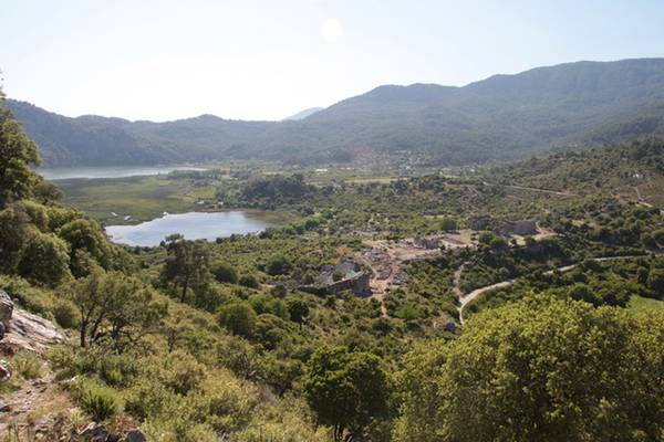 Aussicht vom Dalyan Resort Hotel auf eine Landschaft mit einem See, Bergen und Ruinen.