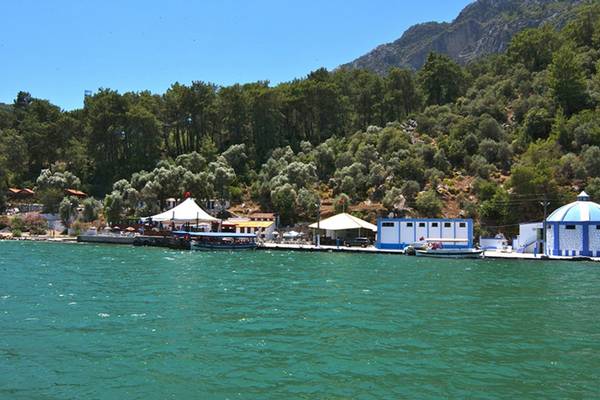 Blick auf den Hafen des Dalyan Resort Hotels mit Booten und Gebäuden am Ufer.