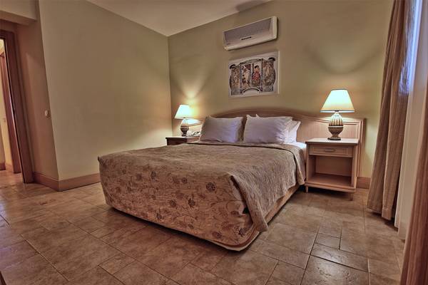 Bettzimmer im Dalyan Resort Hotel mit zwei Nachttischen und Lampen.