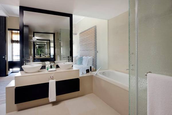 Badezimmer im Southern Sun Abu Dhabi Hotel mit zwei Waschbecken und Badewanne.