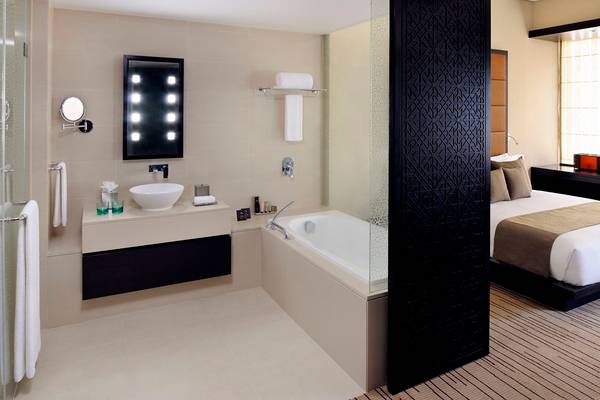 Hotelzimmer mit Badezimmer und Bett im Southern Sun Abu Dhabi