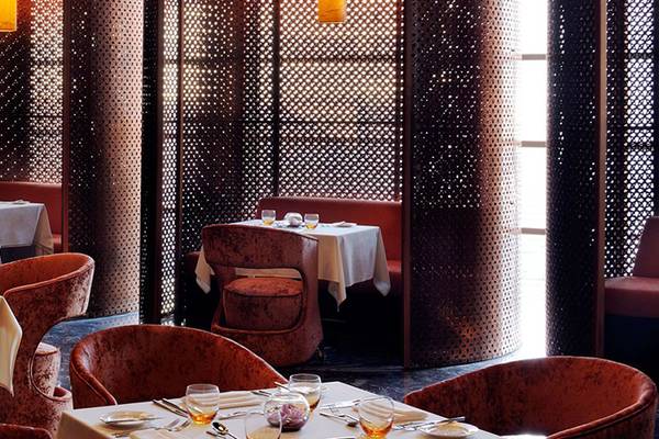 Innenansicht des Restaurants im Southern Sun Abu Dhabi mit braunen Stühlen und Tischen.