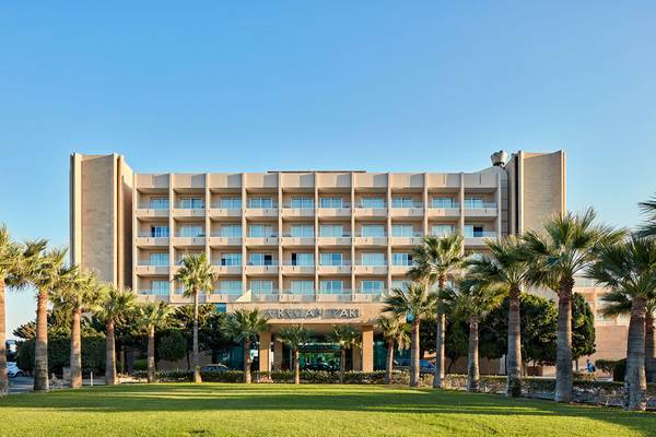 Außenansicht des Grecian Park Hotels mit vielen Fenstern und Palmen vor dem Gebäude