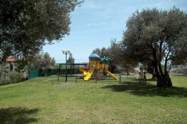Ein Kinderspielplatz im Kampos Village Resort mit einem gelben Rutschen und einem blauen Dach.