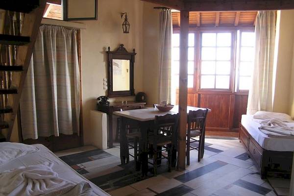 Ein Hotelzimmer im Kampos Village Resort mit zwei Betten, einem Tisch und Stühlen sowie einem Spiegel.