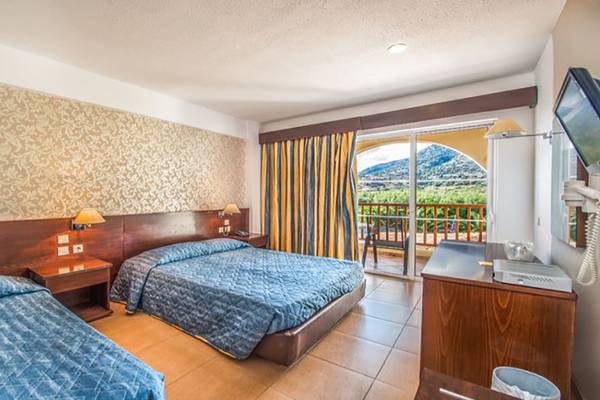 Zwei Betten in einem Hotelzimmer mit einem Balkon und einer Aussicht auf einen Berg.