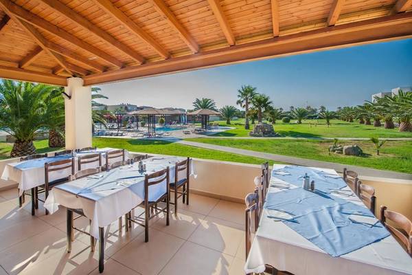 Akti Beach Club Hotel Terrasse mit Tisch und Stühlen mit Blick auf einen Golfplatz