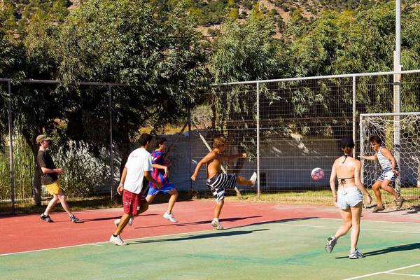 Personen spielen Fußball auf einem Feld im Freien am Akti Beach Club.