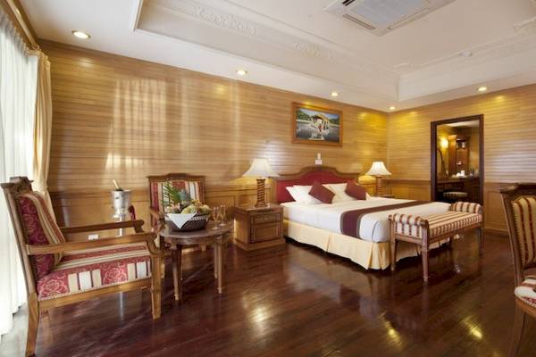 Schlafzimmer im Royal Island Resort & Spa mit einem großen Bett, Holzmöbeln und einer Gemälde an der Wand.