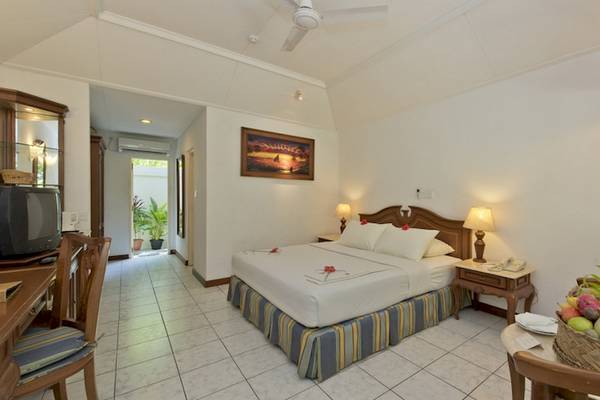 Hotelzimmer im Royal Island Resort & Spa mit Bett, Tisch, Fernseher und Früchtekorb