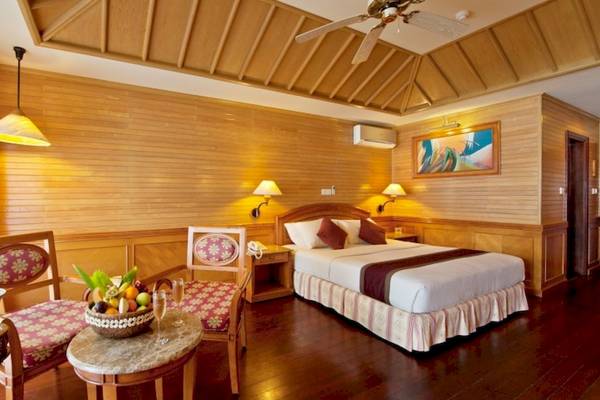 Hotelzimmer im Royal Island Resort & Spa mit Bett, Obstkorb, Stühle und Deckenventilator.