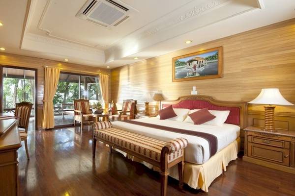Hotelzimmer im Royal Island Resort & Spa mit Fernseher, Bett, Möbeln und Panoramafenstern.