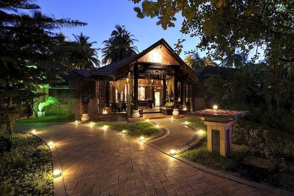Das Royal Island Resort & Spa bei Nacht mit beleuchtetem Weg und Außenbeleuchtung.