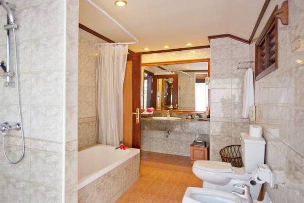 Ein Badezimmer im Royal Island Resort & Spa mit Badewanne, Dusche, Toilette und Waschbecken.