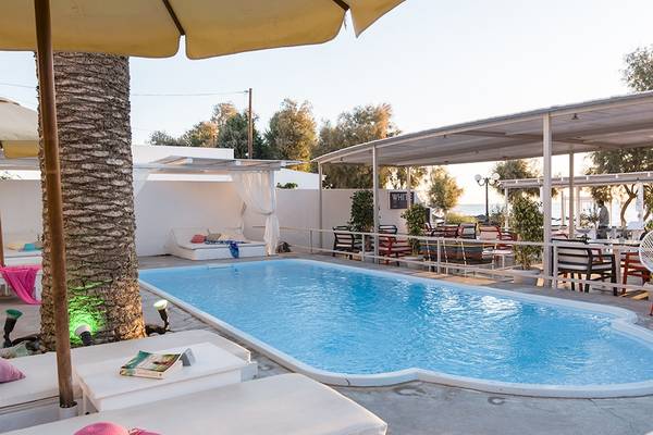 Außenbereich des Beach Boutique Hotels mit Pool, Liegestühlen und Sonnenschirmen.