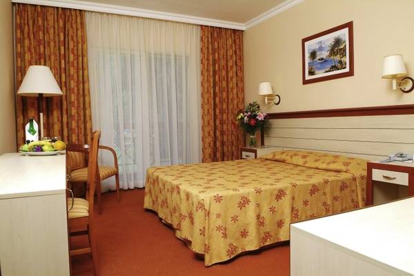 Hotelzimmer des Kustur Club Holiday Village mit Bett, Schreibtisch und Früchten