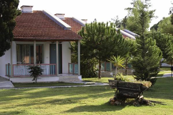 Einfamilienhaus des Kustur Club Holiday Village mit Rasen und Bäumen davor