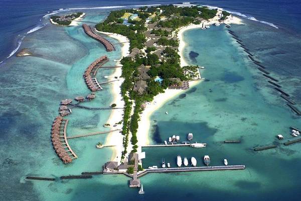 Luftaufnahme des Sheraton Maldives Voller Mond Resorts & Spa mit vielen Gebäuden und Booten im Wasser.