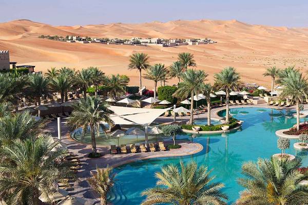 Luftaufnahme des Qasr Al Sarab Desert Resort Pools mit Blick auf die Wüste