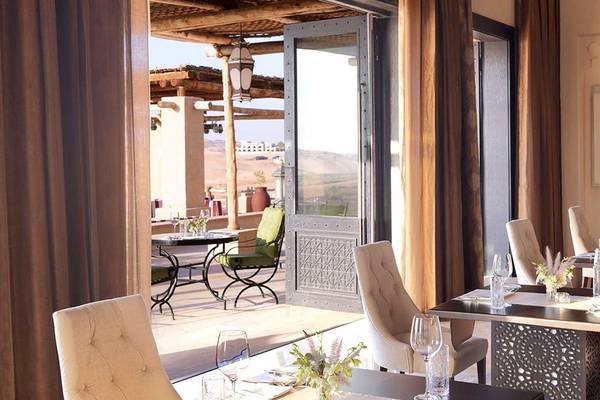 Innenansicht des Restaurants im Hotel Qasr Al Sarab Desert Resort by Anantara mit Blick auf den Garten