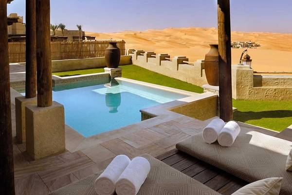 Außenpool mit Liegen und Handtüchern im Qasr Al Sarab Desert Resort von Anantara.