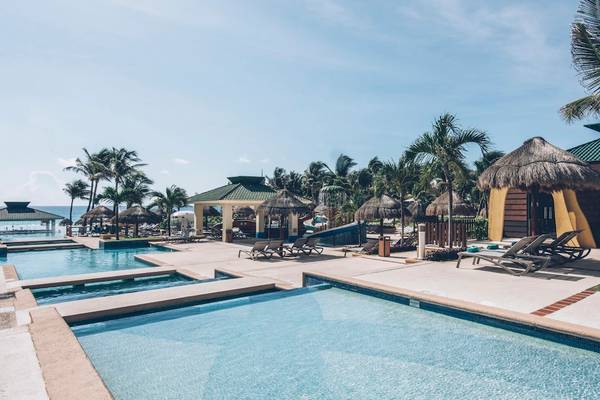 Außenpool im Iberostar Selection Cancun Hotel mit Sonnenliegen und Palmen