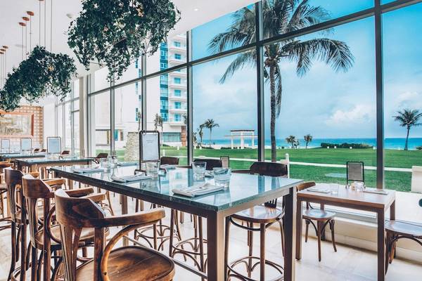 Speisesaal im Iberostar Selection Cancun mit Blick auf das Meer und Palmen