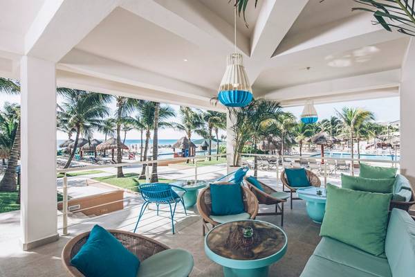 Loungebereich des Iberostar Selection Cancun Hotels mit Blick auf den Pool und das Meer.