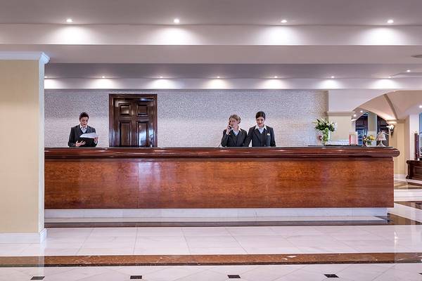 Empfangsbereich des Mitsis Grand Hotel Beach mit zwei Mitarbeiterinnen am Empfangsschalter.