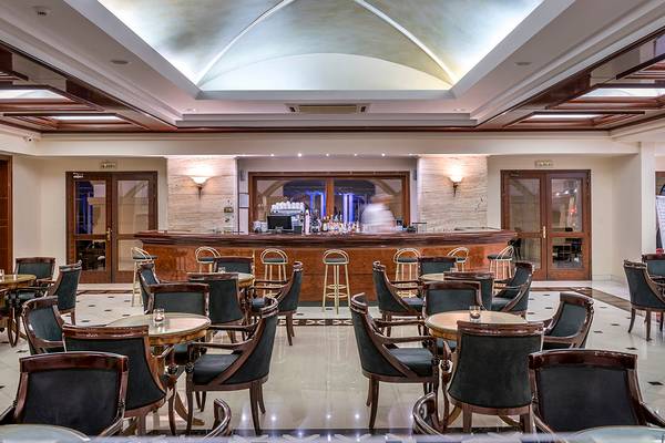 Innenansicht der Bar im Mitsis Grand Hotel Beach mit Theke und Sitzgelegenheiten.