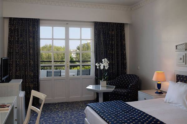 Ein elegant eingerichtetes Hotelzimmer mit Doppelbett, Tisch, Stuhl und Fernseher.