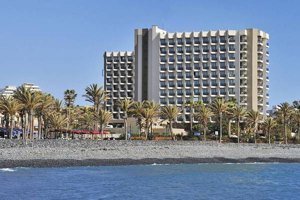 Außenansicht des Sol Tenerife Hotels an der Küste mit Palmen und Meer im Hintergrund