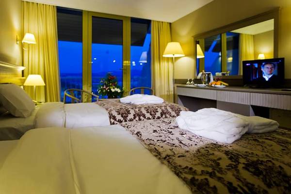 Doppelzimmer im Fantasia Hotel De Luxe mit zwei Betten, Fernseher und Aussichtsfenster.