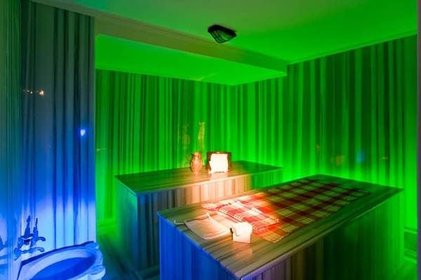 Sauna im Fantasia Hotel De Luxe mit grünen Wänden und rot-weiß kariertem Tischtuch.