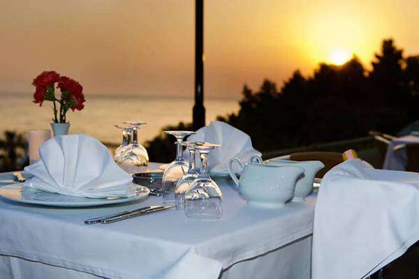 Sonnenuntergang über dem Meer mit einem elegant gedeckten Tisch im Fantasia Hotel De Luxe.