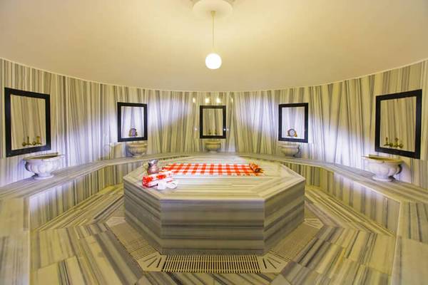 Innenansicht der Sauna im Fantasia Hotel De Luxe mit achteckigem Dampfbad und marmorierten Wänden.