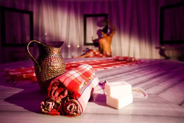 Massagebereich im Fantasia Hotel De Luxe mit Kissen, Seifenstücken und Krug.