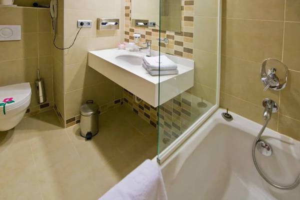 Badezimmer im Fantasia Hotel De Luxe mit Badewanne, Dusche, Toilette und Waschbecken.