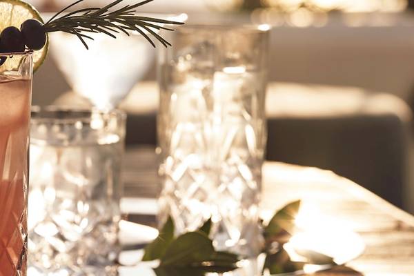 Cocktail im Glas mit Rosmarin und Limette auf einem Tisch
