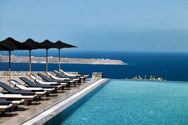 Außenpool mit Liegen und Sonnenschirmen im Santo Pure Oia Suites & Villas