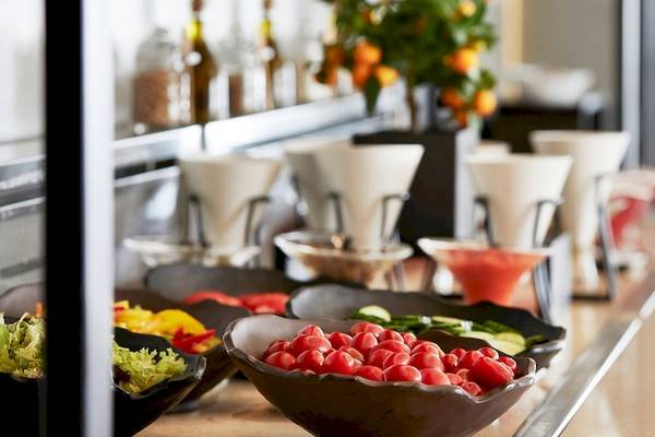 Buffettisch im Hotel Santo Pure Oia Suites & Villas mit verschiedenen Salat- und Tomatenschüsseln.