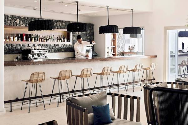 Innenansicht des Hotels Santo Pure Oia Suites & Villas mit Bar, Barkeeper und Möbeln.